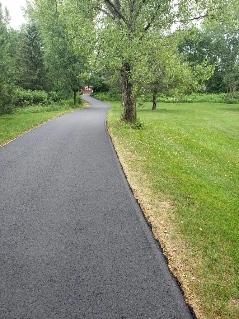 Long-Asphalt-Driveway-Through-Trees-Leading-to-a-Red-House-768x1024